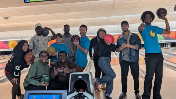 International students at the bowling alley posing with bowling balls.