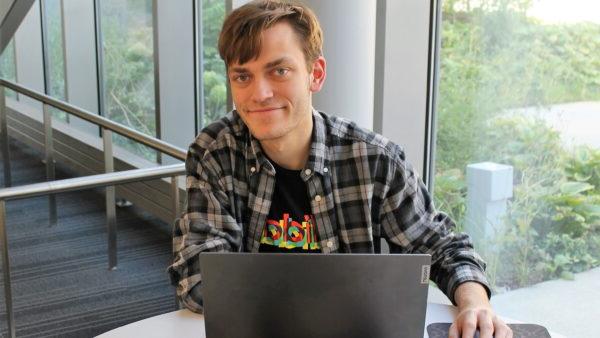 a person sitting at a table with a laptop