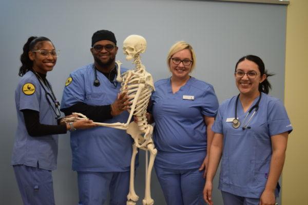 a group of medical professionals posing with a skeleton